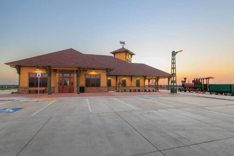 Exterior image of the Dental Depot dental office in Northwest Oklahoma City with a yellow exterior, red roof, and the sun setting behind the clinic.