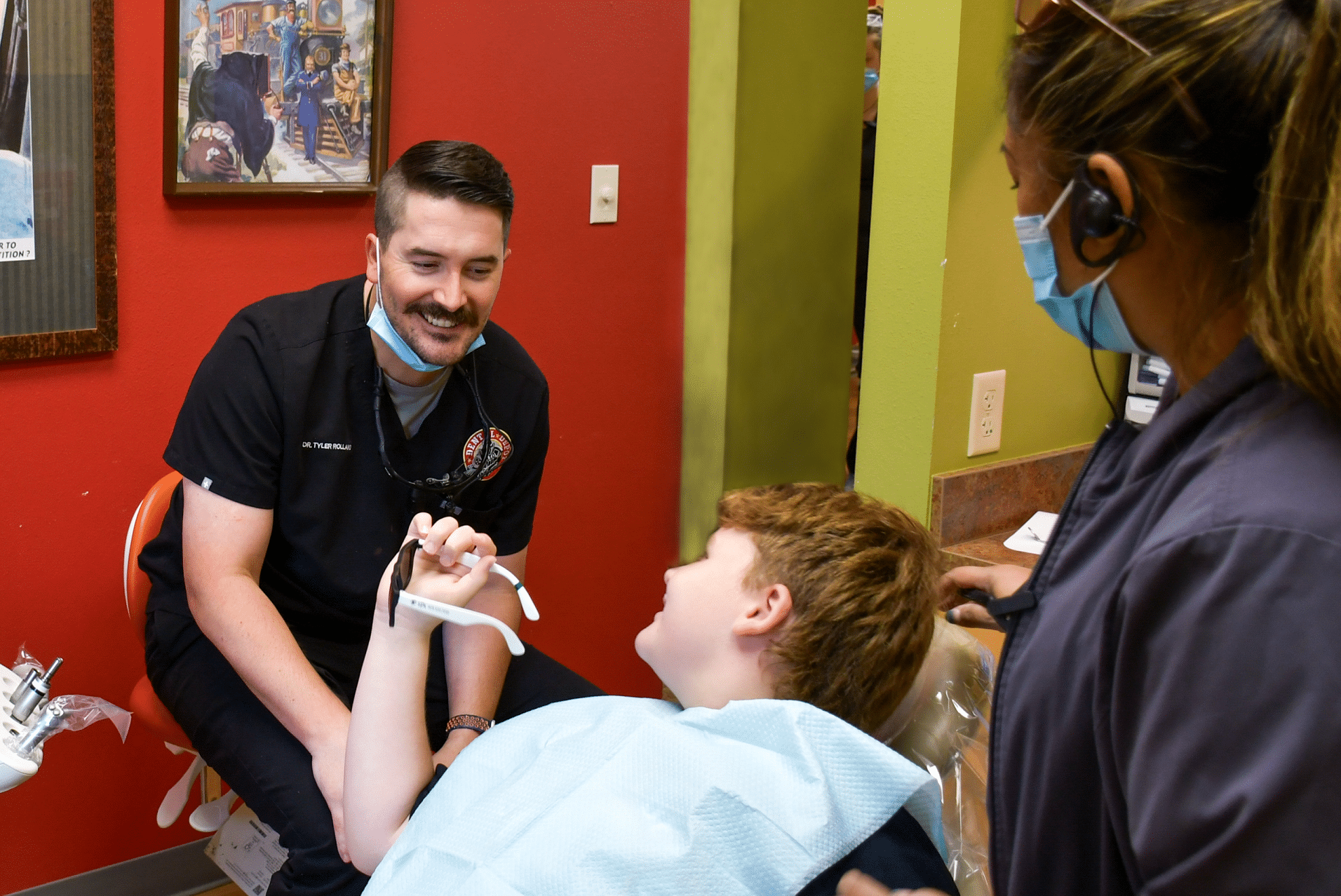 Dr. Tyler Rolland, Dentist in Broken Arrow, smiles at a young dental patient after providing care.