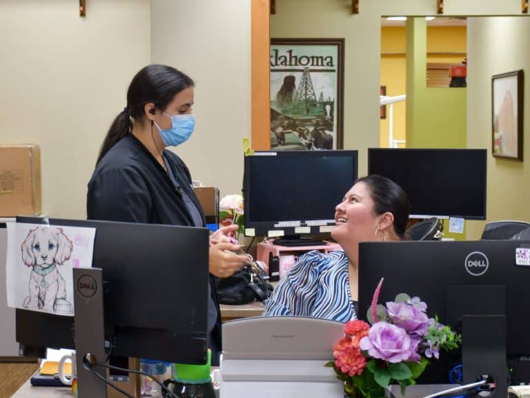 Central Tulsa's dental clinic reception desk with members of the dental team smiling.