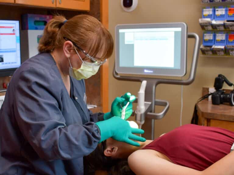 A dentist at Dental Depot's dental clinic in Yukon examines a patient.