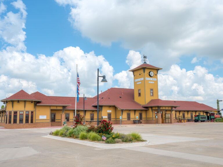 Exterior view of Dental Depot's Yukon dental office with a flagpole, yellow walls, and a red roof.