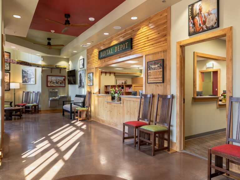 Tulsa Hills dental clinic waiting room and reception area with train themed signage and red and green furniture