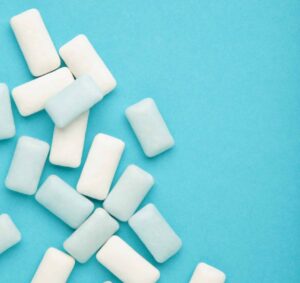 White pieces of gum scattered on a blue background.