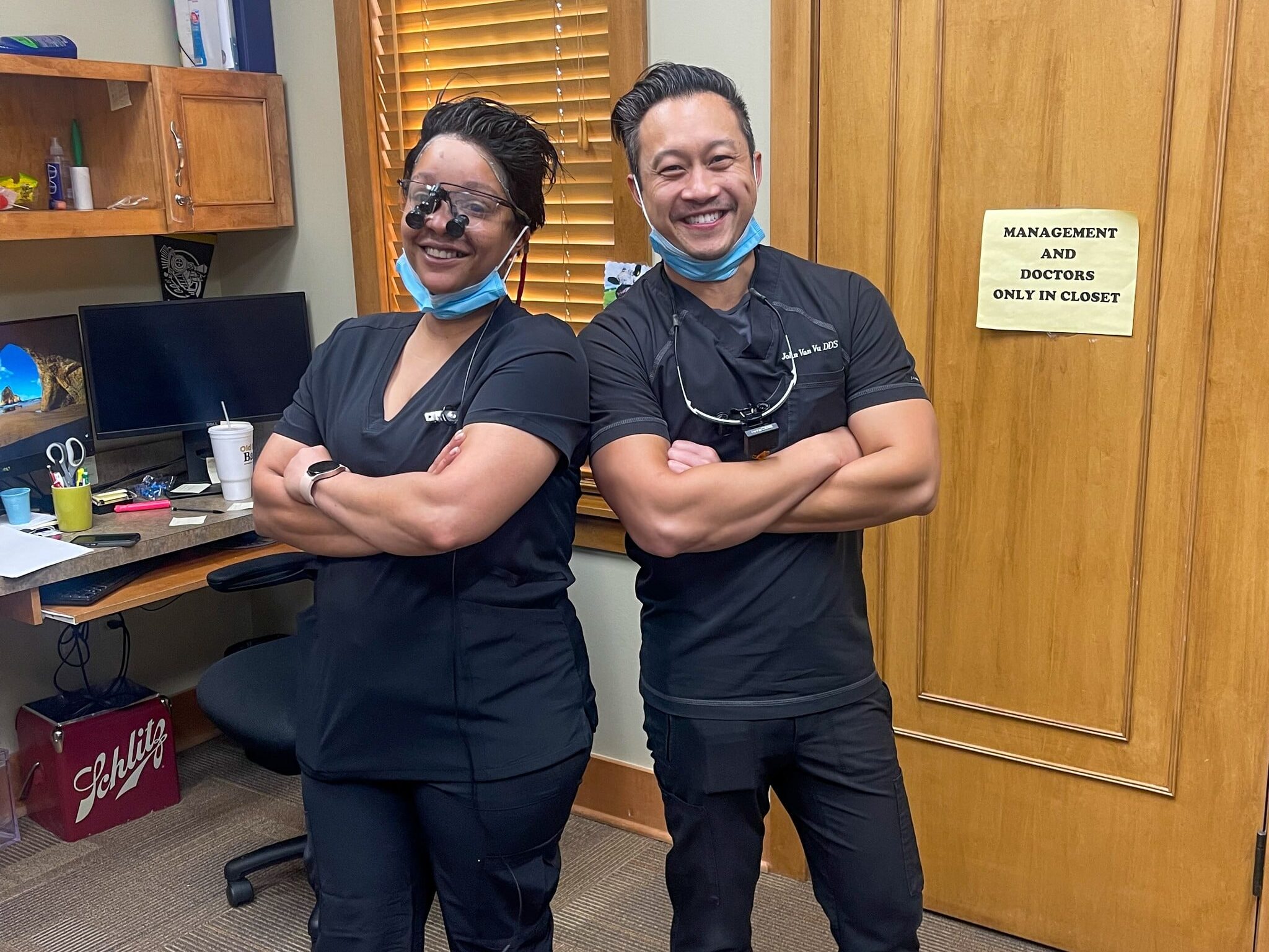 Dental Depot's North OKC Dentists strike a pose back to back with their arms crossed and big smiles.