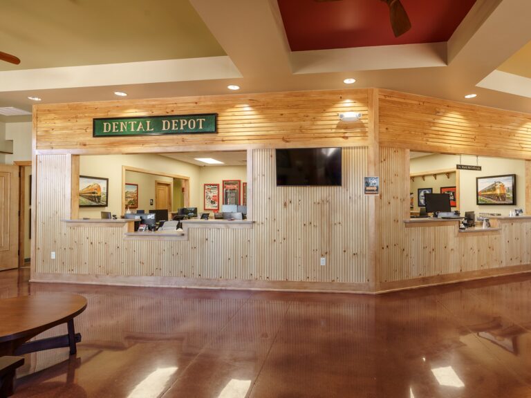 Dental Depot's NW 63rd St dental clinic's reception area with light colored wood and train theme signage.