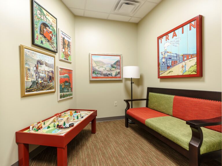 Waiting room at Dental Depot's NW 63rd St Oklahoma City Dental office with toys and train themed pictures on the walls.