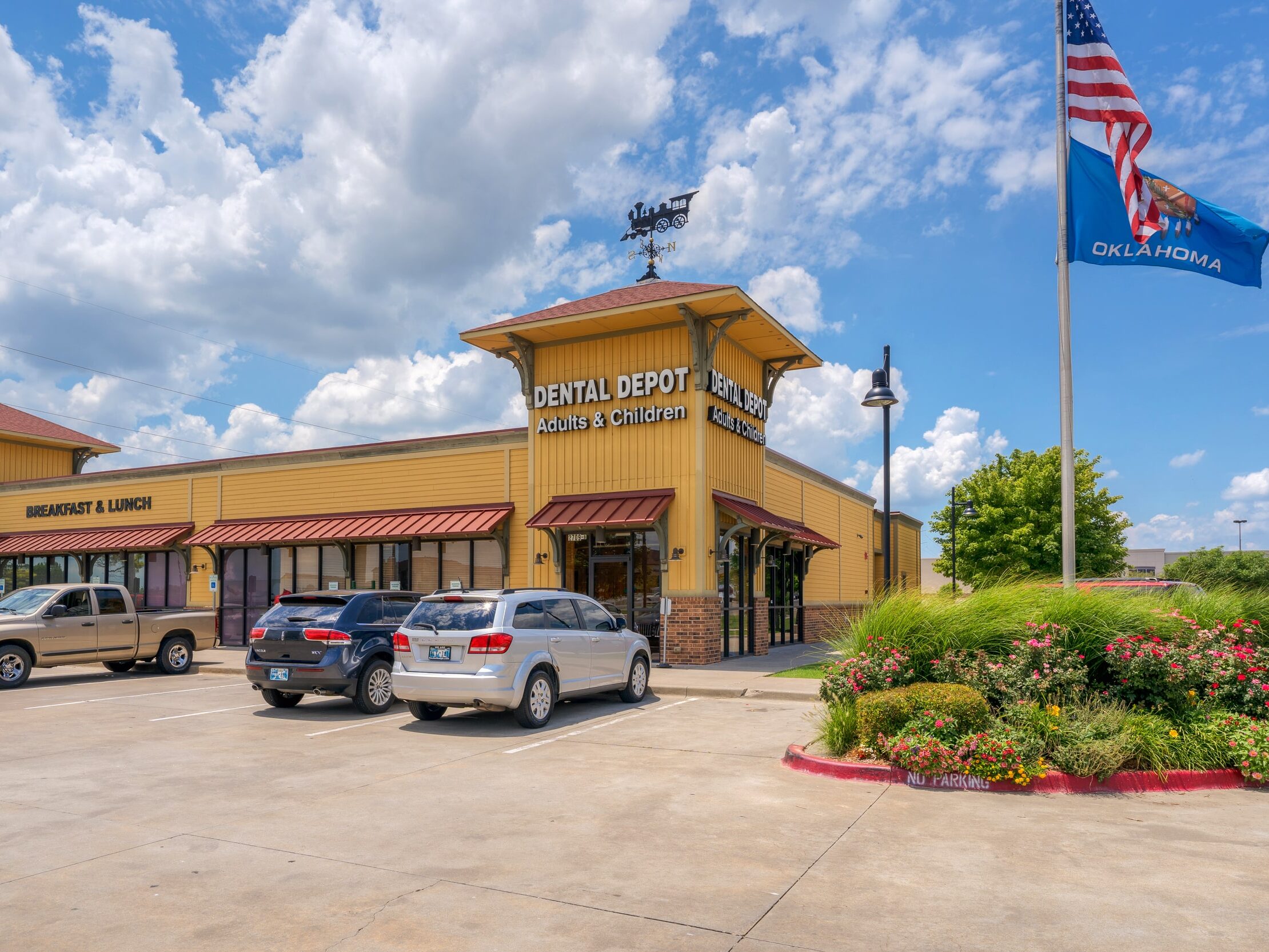 Exterior view of Dental Depot's Moore dental clinic with yellow walls and a red roof.