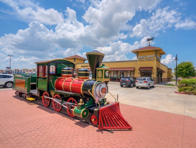 Exterior image of Dental Depot's Moore dentist office with a model train in front.