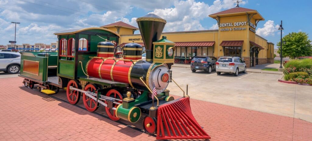 Exterior image of Dental Depot's Moore dentist office with a model train in front.
