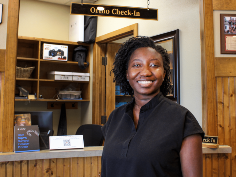 Dr. Augusta poses for a photo near the reception desk at Dental Depot's South OKC dentist office