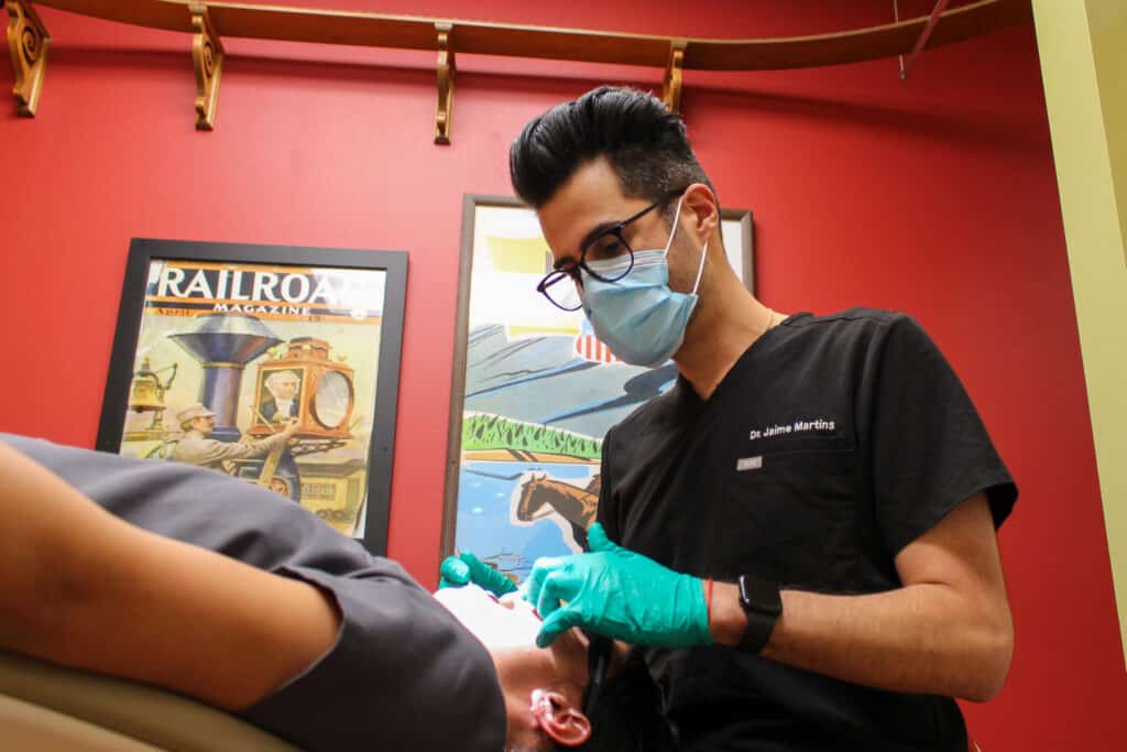 Action shot of orthodontist Dr. Jaime Martins, as he works with an orthodontic patient for Dental Depot of West Norman Oklahoma.