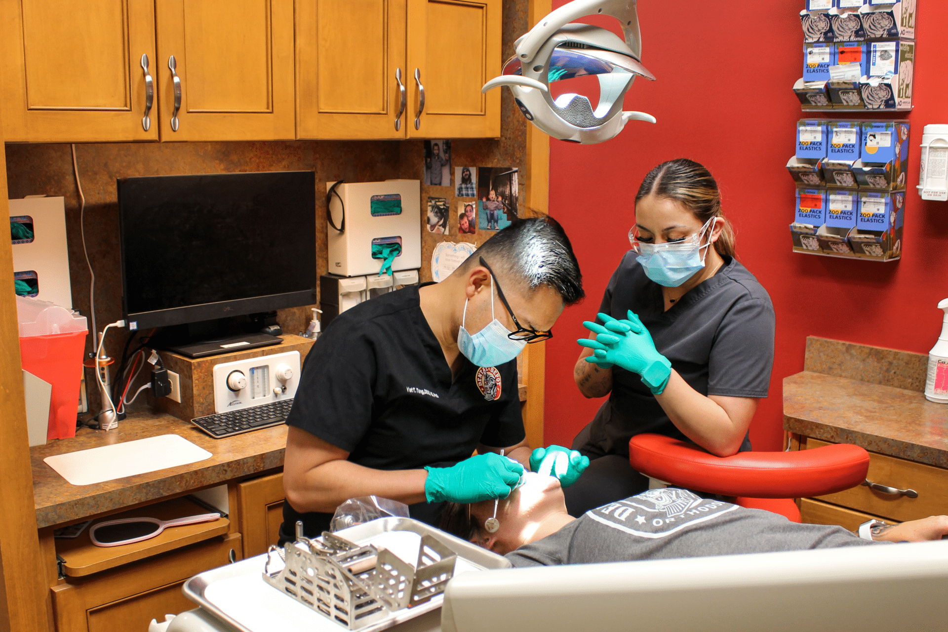 Dental Depot dentists examine a patient in a red exam room.