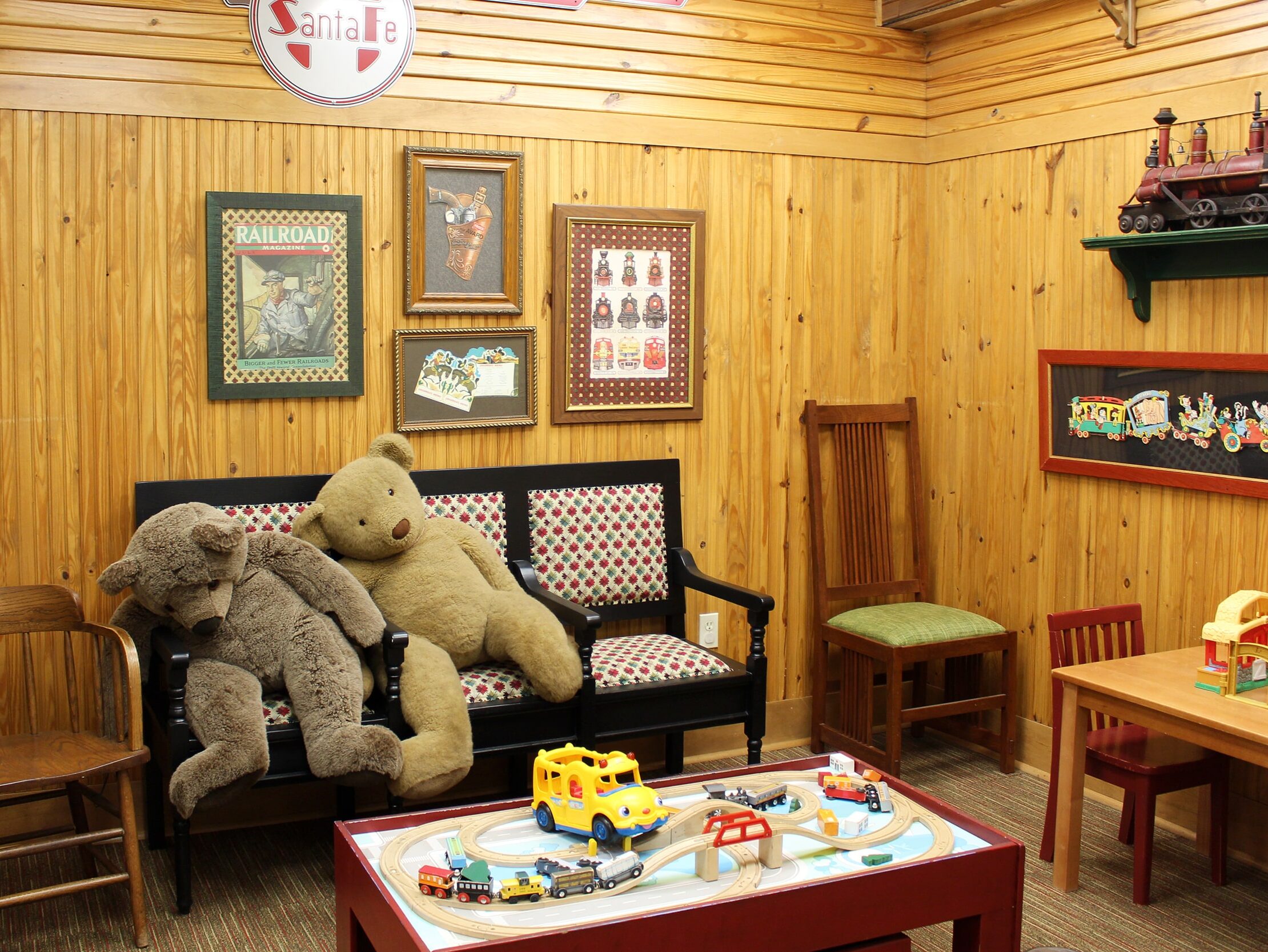 Interior view of the Edmond dental clinic's waiting room with a couch, stuffed animals, and games.