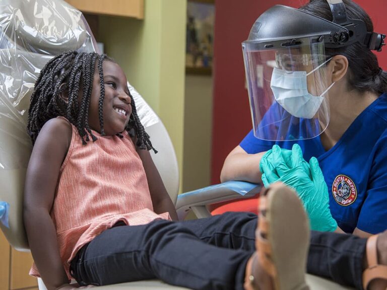 A small child talks with a dental hygienist at dental depot