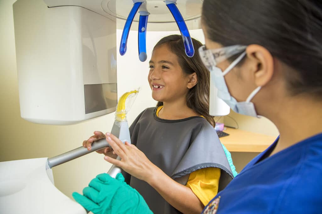 A girl gets ready for dental xrays at dental depot