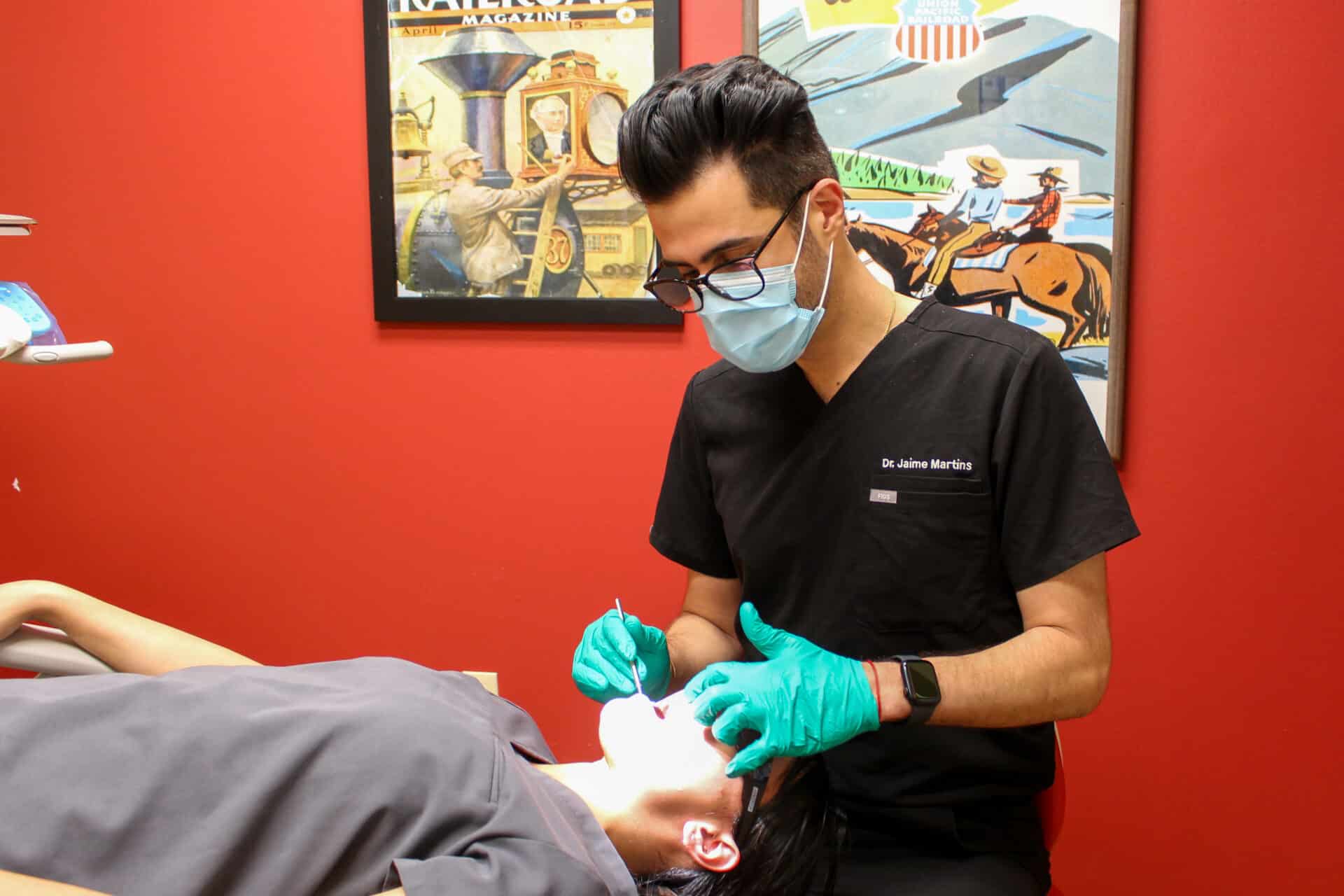 An orthodontist works on a patient in a red operatory at Dental Depot.