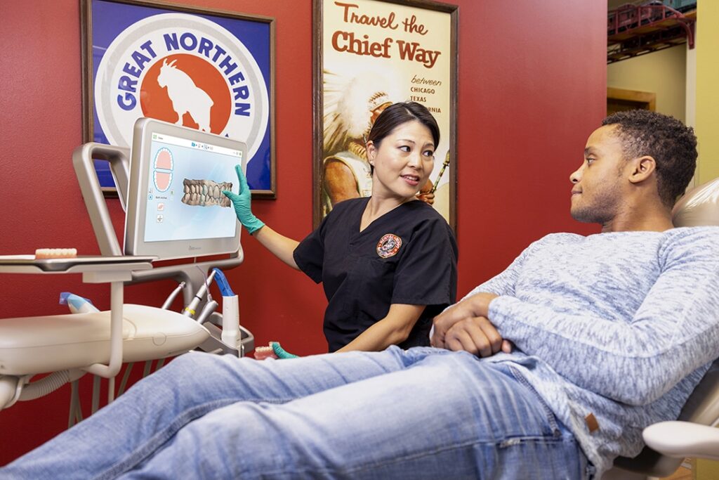 A dentist at Dental Depot explains a treatment plan to an adult patient.