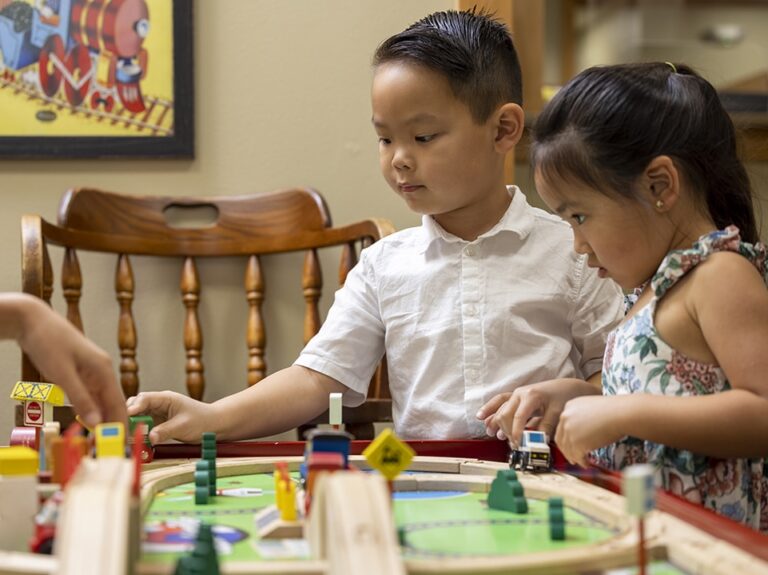 Small children play with a train set in the lobby of dental depot