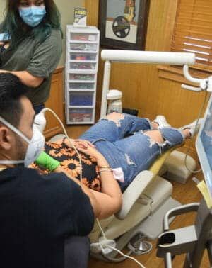 kid receiving dental work while in chair