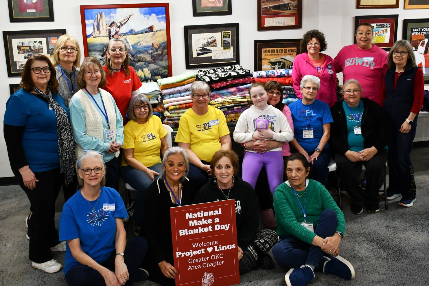 Many women smile for the camera in front of their hand-made blankets for National Make a Blanket Day with Project Linus for Dental Depot.