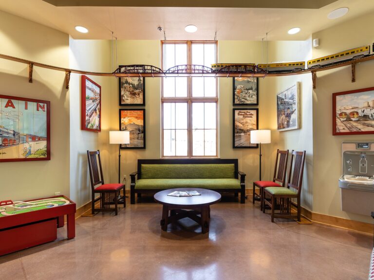 Tulsa Hills dental clinic waiting room and reception area with train themed signage and a model train running around the top of the room.