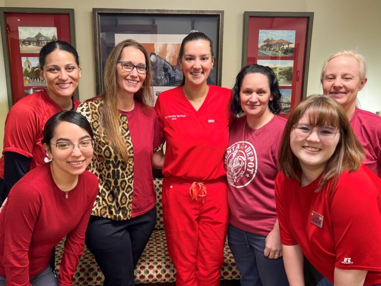 The dental team poses in red at Dental Depot's West Oklahoma City dental clinic